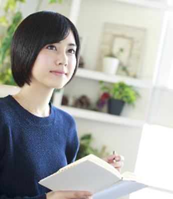 英語の本を手に持っている女性