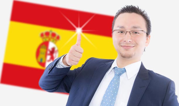 スペイン国旗をバックにサムズアップしている外国人男性